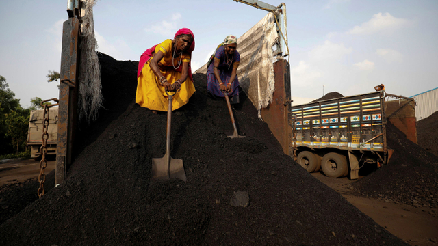 Pekerja menurunkan batu bara dari truk pasokan di halaman di pinggiran Ahmedabad, India. Foto: REUTERS/Amit Dave