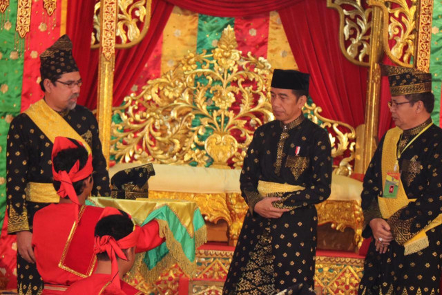 KETUA Umum Majelis Kerapatan Adat Melayu Lembaga Adat Melayu Riau (MKA LAMR), Datuk Seri Al Azhar (kiri) saat penabalan gelar adat untuk Presiden Joko Widodo. 