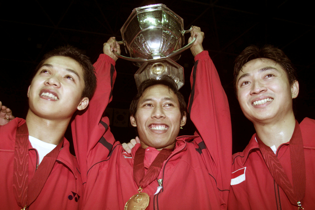 Sigit Budiarto memegang trofi Piala Thomas usai mengalahkan Malaysia di Guangzho, pada 19 Mei 2002. Foto: Bobby Yip/REUTERS