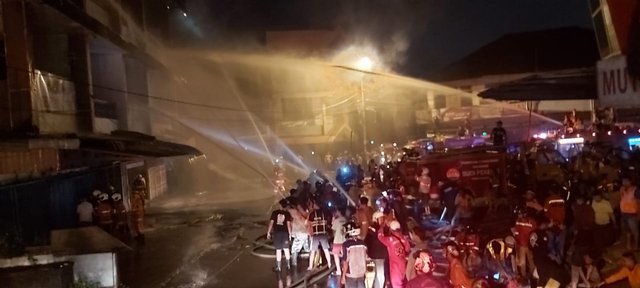 Petugas pemadam kebakaran berupaya memadamkan apiyang membakar ruko di Pasar Mawar Pontianak. Foto: Leo Prima/Hi!Pontianak