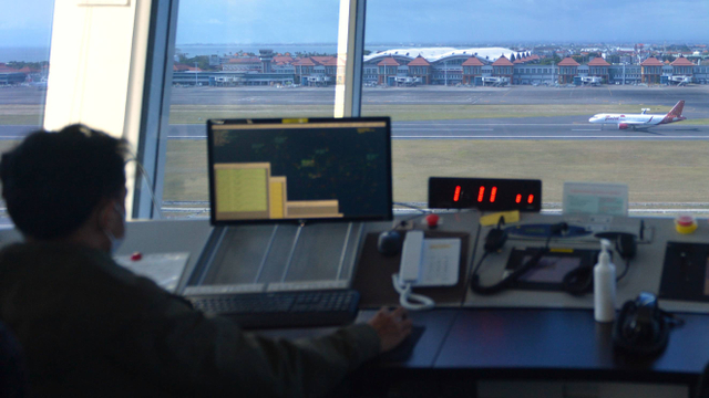 Petugas memantau dan mengatur pergerakan pesawat udara di menara Air Traffic Controller (ATC) Bandara Internasional I Gusti Ngurah Rai, Bali, Rabu (13/10/2021). Foto: Fikri Yusuf/Antara Foto