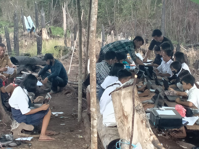 Pelajar SMPN 4 Ketungau Hulu di Desa Nanga Bayan mengikuti ujian di puncak bukit menggunakan sinyal Malaysia. Foto: Dokumen Hi! Pontianak