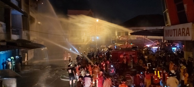 Petugas pemadam kebakaran memadamkan api yang membakar 4 ruko di kawasan Pasar Mawar Pontianak. Foto: Leo Prima/Hi!Pontianak