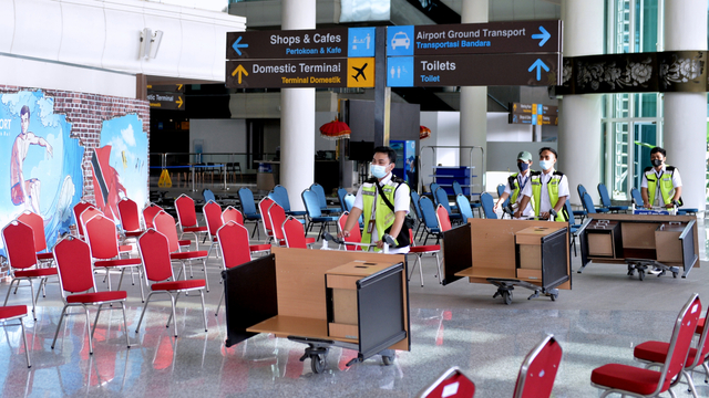 Petugas melintas saat hari pertama pembukaan kembali penerbangan internasional di area Terminal Internasional Bandara Internasional I Gusti Ngurah Rai, Badung, Bali, Kamis (14/10/2021). Foto: Fikri Yusuf/ANTARA FOTO