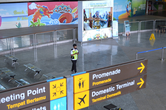 Petugas melintas saat hari pertama pembukaan kembali penerbangan internasional di area Terminal Internasional Bandara Internasional I Gusti Ngurah Rai, Badung, Bali, Kamis (14/10/2021). Foto: Fikri Yusuf/ANTARA FOTO