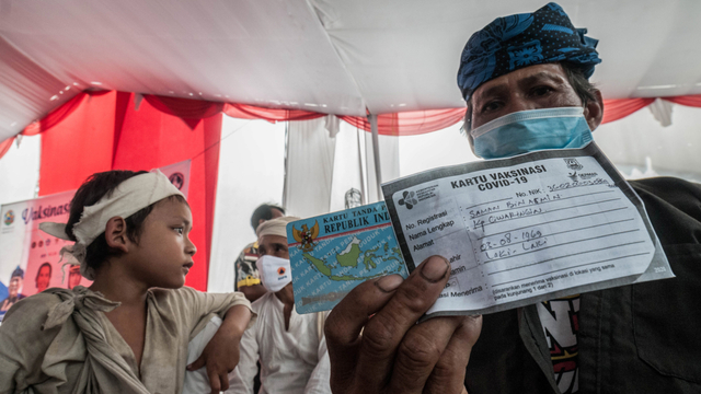 Warga Baduy menunjukkan kartu vaksin COVID-19 di Ciboleger, Lebak, Banten, Kamis (14/10/2021). Foto: Muhammad Bagus Khoirunas/ANTARA FOTO