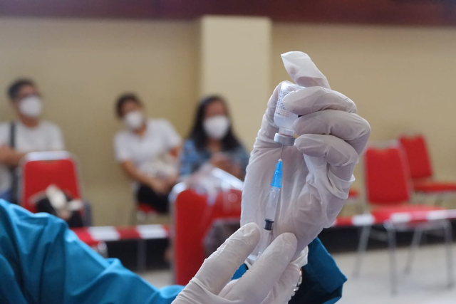 Pemindahan cairan vaksin ke dalam alat suntikan yang dilakukan oleh tenaga vaksinator | Foto : Sidik Aryono/ Lampung Geh