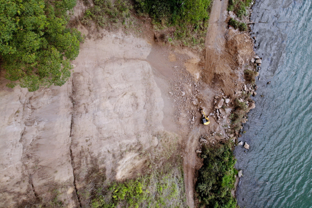 Foto udara petugas yang menggunakan alat berat membersihkan material longsoran bukit akibat gempa bumi Karangasem Bali yang menutup jalan di kawasan Kintamani, Bangli, Bali, Minggu (17/10).  Foto: Fikri Yusuf/ANTARA FOTO