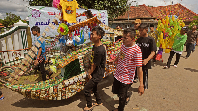 Sejumlah warga menggotong barang sedekah saat Perayaan Maulid Nabi Muhammad di Kampung Sukalila, Kelapa Dua, Serang, Banten, Selasa (19/10/2021). Foto: Asep Fathulrahman/ANTARA FOTO