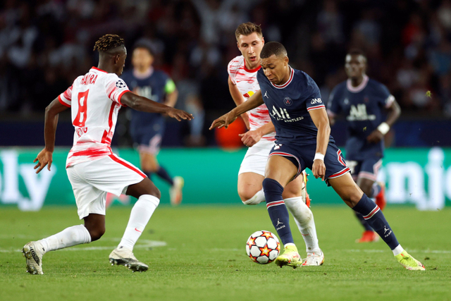 Pemain Paris St Germain (PSG) Kylian Mbappe berusaha melewati pemain RB Leipzig Amadou Haidara pada pertandingan Grup A Liga Champions di Parc des Princes, Paris, Prancis.  Foto: Christian Hartmann/REUTERS