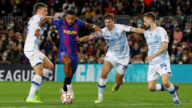Pemain FC Barcelona Memphis Depay berusaha melewati hadangan pemain Dynamo Kyiv pada pertandingan Grup E Liga Champions di Camp Nou, Barcelona, Spanyol. Foto: Albert Gea/REUTERS
