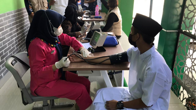 Seorang pelajar tampak sedang melakukan pemeriksaan kesehatan sebelum mendapatkan suntikan vaksin corona, dalam gelaran Vaksinasi Massal yang digelar GP Ansor Sulut dalam rangka Hari Santri Nasional