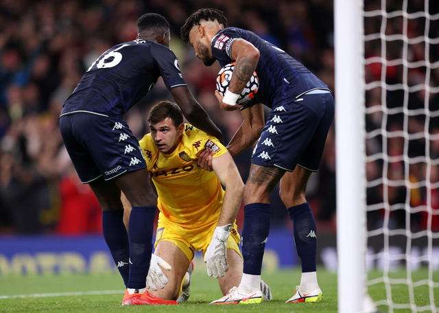 Pemain Aston Villa Axel Tuanzebe dan Tyrone Mings membantu Emiliano Martinez setelah mereka kebobolan gol kedua oleh Arsenal di Stadion Emirates, London, Inggris, Jumat (22/10). Foto: Alex Pantling/Getty Images