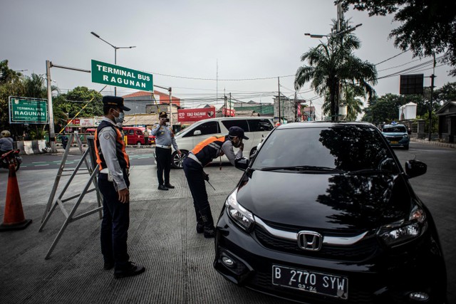 Petugas Dishub DKI Jakarta mengimbau pengendara kendaraan berpelat nomor genap untuk berputar balik saat penerapan ganjil genap di depan pintu masuk Taman Margasatwa Ragunan, Jakarta, Sabtu (23/10). Foto: Aprillio Akbar/ANTARA FOTO