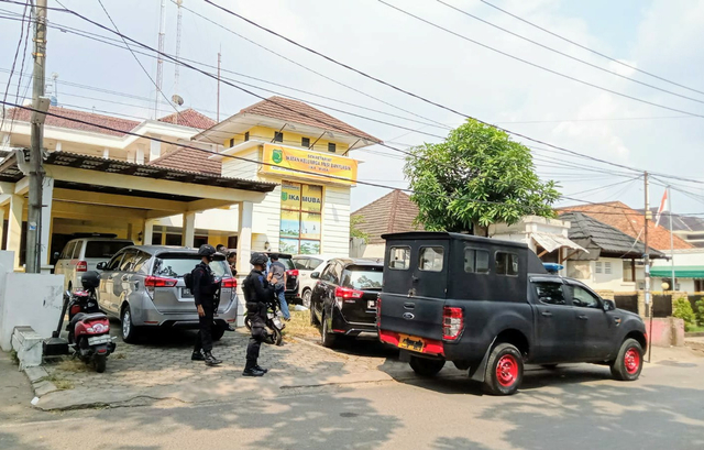 Anggota Brimob Polda Sumsel melakukan penjagaan saat penggeledahan tim KPK di kantor Sekretariat IKA-Muba. (foto: istimewa)