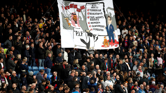 Penggemar Crystal Palace dengan spanduk tentang pengambilalihan Newcastle United sebelum pertandingan di Selhurst Park, London, Inggris, Sabtu (23/10). Foto: Peter Nicholls/REUTERS