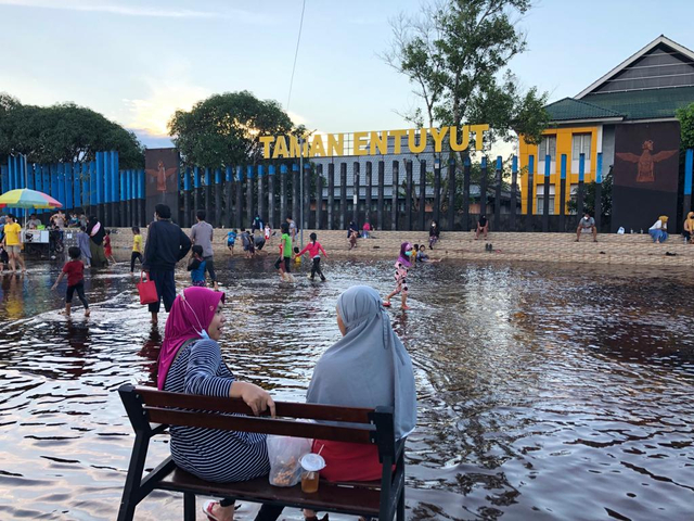 Banjir yang menggenangi Taman Entuyut di kawasan Tugu Bank Indonesia Sintang dimanfaatkan anak-anak untuk bermain.(Foto: Yusrizal/Hi! Pontianak)