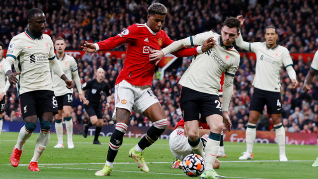 Pemain Manchester United Marcus Rashford beraksi dengan pemain Liverpool Andrew Robertson di Stadion Old Trafford, Manchester, Inggris, Minggu (24/10). Foto: Phil Noble/REUTERS