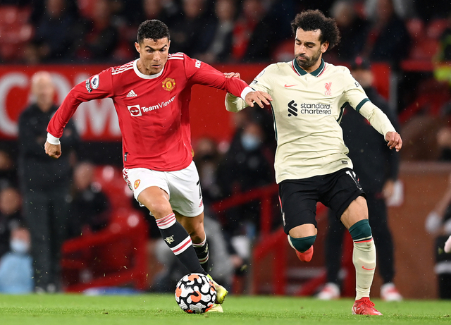 Pemain Manchester United Cristiano Ronaldo beraksi dengan pemain Liverpool Mohamed Salah di Stadion Old Trafford, Manchester, Inggris, Minggu (24/10). Foto: Michael Regan/Getty Images