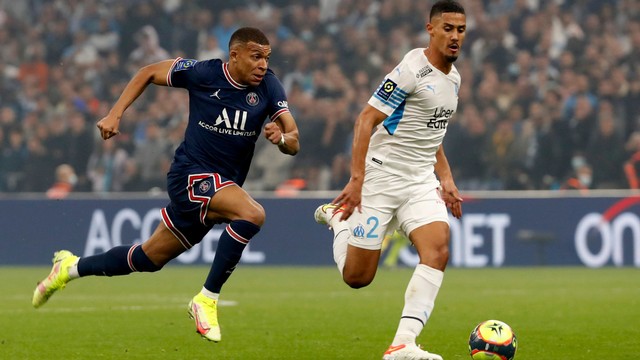 Pemain Paris St Germain Kylian Mbappe beraksi dengan pemain Olympique de Marseille William Saliba di Orange Velodrome, Marseille, Prancis, Minggu (24/10). Foto: Eric Gaillard/REUTERS