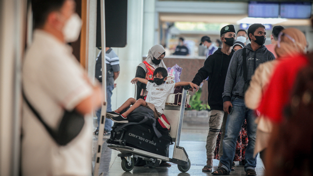 Calon penumpang pesawat membawa anaknya di Bandara Internasional Juanda Surabaya di Sidoarjo, Jawa Timur, Senin (25/10/2021). Foto: Umarul Faruq/ANTARA FOTO