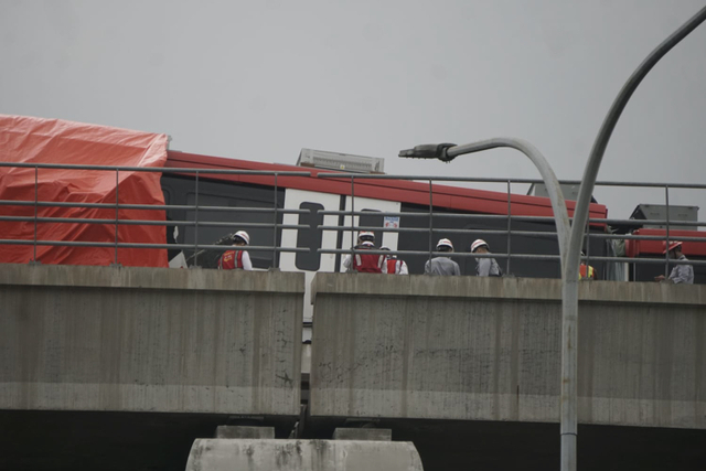 Petugas meninjau kondisi LRT Jabodebek yang tabrakan di Munjul, Jakarta Timur (25/10).  Foto: Iqbal Firdaus/kumparan