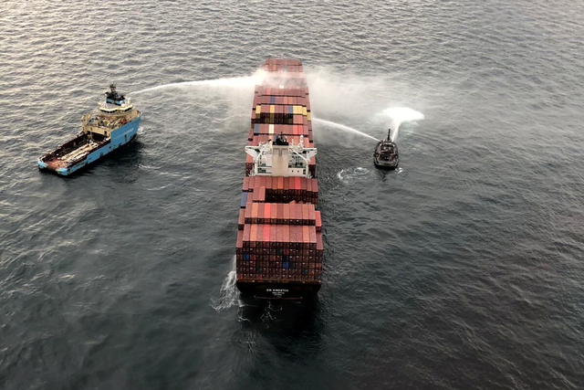 Kapal tunda penyelamat memadamkan kapal kontainer Zim Kingston setelah kru dievakuasi karena kebakaran di Victoria, British Columbia, Kanada Minggu (24/10/2021). Foto: Canadian Coast Guard via Reuters