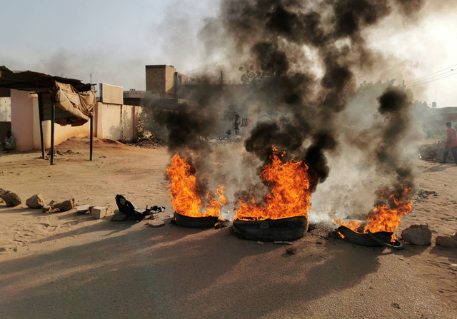 Warga memasang barikade jalan dari batu dan ban yang dibakar saat kudeta militer di Khartoum, Sudan, Senin (25/10/2021). Foto: El Tayeb Siddig/ Reuters