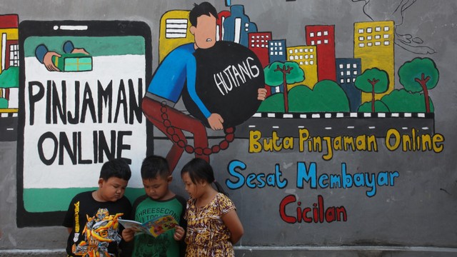 Sejumlah anak membaca bersama di dekat dinding bermural di kawasan Tempurejo, Surabaya, Jawa Timur, Selasa (7/9).  Foto: Didik Suhartono/ANTARA FOTO