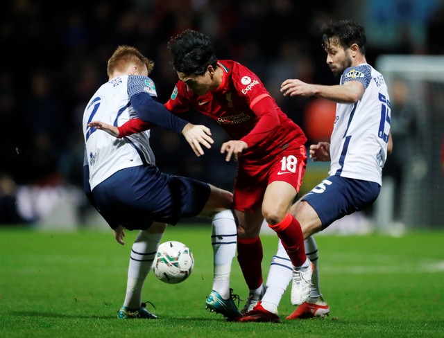 Pemain Liverpool Takumi Minamino duel dengan pemain Preston North End Sepp van den Berg dan Joseph Rafferty di Deepdale, Preston, Inggris, Rabu (27/10/2021). Foto: Lee Smith/Reuters