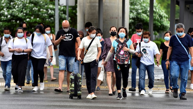 Warga yang memakai masker wajah menyeberang jalan di tengah wabah penyakit coronavirus (COVID-19) di Singapura. Foto: Caroline Chia/REUTERS