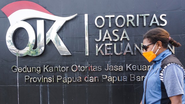 Seorang warga melintas di depan kantor Otoritas Jasa Keuangan (OJK). Foto: ANTARA FOTO/Indrayadi TH