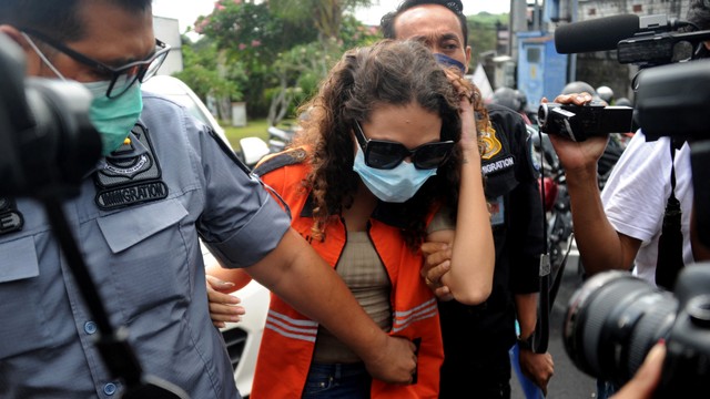 Warga negara Amerika Serikat, Heather Mack, digiring petugas imigrasi setelah memperoleh status bebas murni di Lapas Kerobokan, Badung, Bali, Jumat (29/10/2021). Foto: Sonny Tumbelaka/AFP