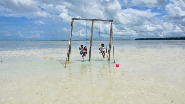 Anak-anak bermain ayunan di tengah pantai yang surut jauh di Desa Wisata Ohoidertawun, Kabupaten Maluku Tenggara (Malra), Provinsi Maluku, Jumat (29/10/2021). Foto: FB Anggoro/ANTARA FOTO