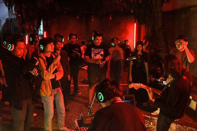 Penonton mendengarkan pertunjukkan musik Bekasi Dekat Musik dengan headphone di Tanaya Coffee Jatimulya, Tambun, Kabupaten Bekasi, Jawa Barat, Jumat (29/10/2021). Foto: Fakhri Hermansyah/Antara Foto