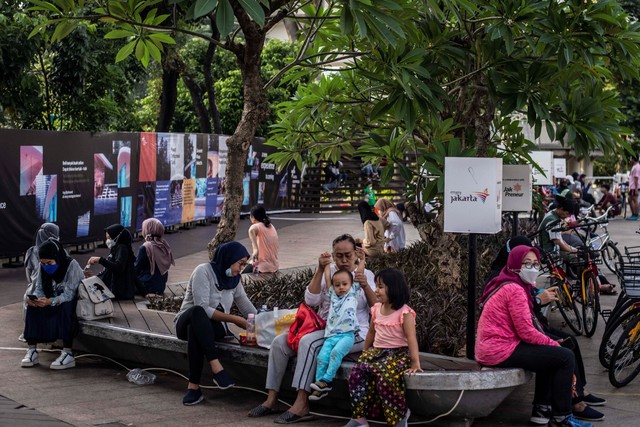 Sejumlah warga duduk di kawasan Dukuh Atas, Jakarta, Minggu (31/10/2021). Foto: Aprillio Akbar/Antara Foto