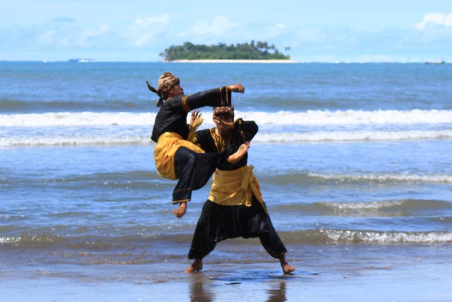 Peserta Festival Silek On The Sea 2021 saat menampilkan atraksi silat tradisi di wisata Pantai Kata, Pariaman, Sumatera Barat. Foto: Langkan/Kumparan