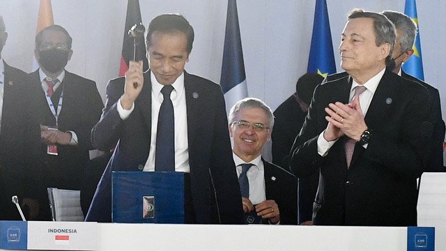 Presiden Joko Widodo (kedua) menerima keketuaan atau Presidensi KTT G20 dari Perdana Menteri Italia Mario Draghi (kanan) pada sesi penutupan KTT G20 di Roma, Italia. Foto: Biro Pers Media Kepresidenan/Laliy Rachev