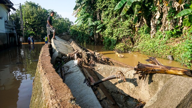 Warga memantau kerusakan tanggul Kali Cakung yang ada di salah satu perumahan di Jati Asih, Bekasi, Jawa Barat (2/11). Foto: Iqbal Firdaus/kumparan