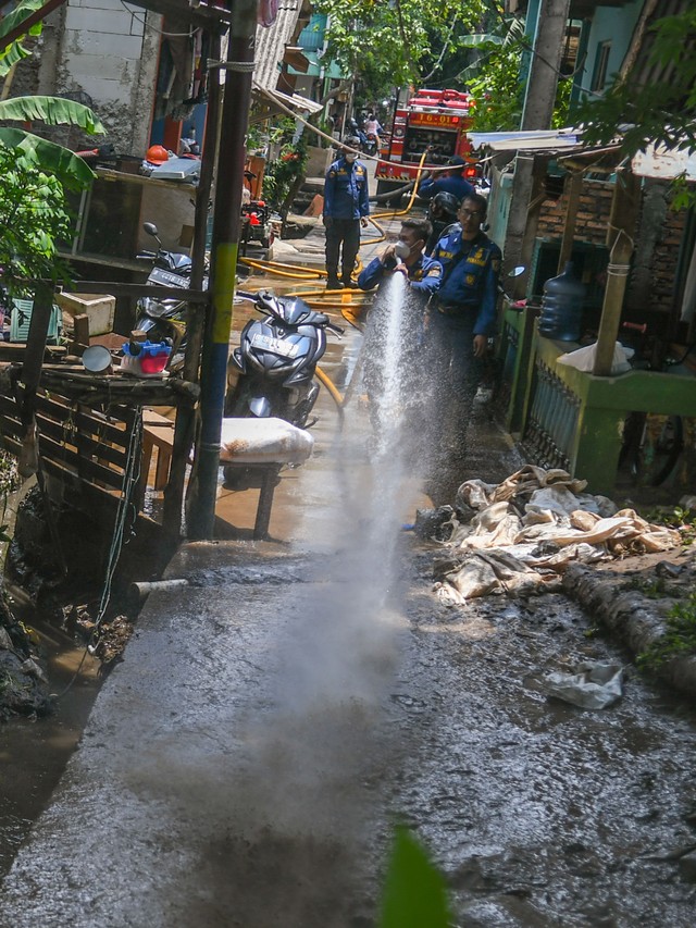 Petugas Penanggulangan Kebakaran dan Penyelamatan (Gulkarmat) membersihkan endapan lumpur sisa banjir di Cipinang Melayu, Jakarta, Selasa (2/11/2021). Foto: Galih Pradipta/ANTARA FOTO