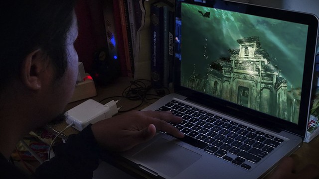 Seseorang melihat Shi Cheng Underwater City di China melalui laptop. Foto: Jamal Ramadhan/kumparan