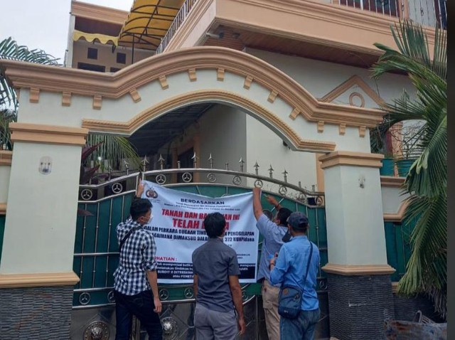Penyidik saat menyita rumah yang dikuasai Anggota DPRD Maluku Utara, Wahda Z Imam. Foto: Istimewa
