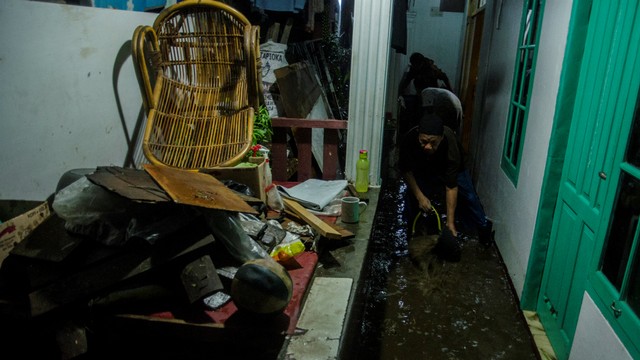 Warga membersihkan rumahnya yang terdampak banjir luapan Sungai Cibeureum di Bandung, Jawa Barat, Selasa (2/11/2021). Foto: Novrian Arbi/ANTARA FOTO