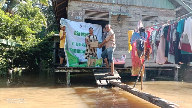 Pihak Agro Andalan menyerahkan bantuan kepada warga terdampak banjir di Peniti. Foto: Dok. Istimewa