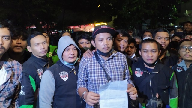 Pengemudi ojek online (ojol), Cahyana, bersama sejumlah rekannya sesama pengemudi ojol mendatangi Polrestabes Bandung pada Senin (8/11) malam. Foto: Rachmadi Rasyad/kumparan