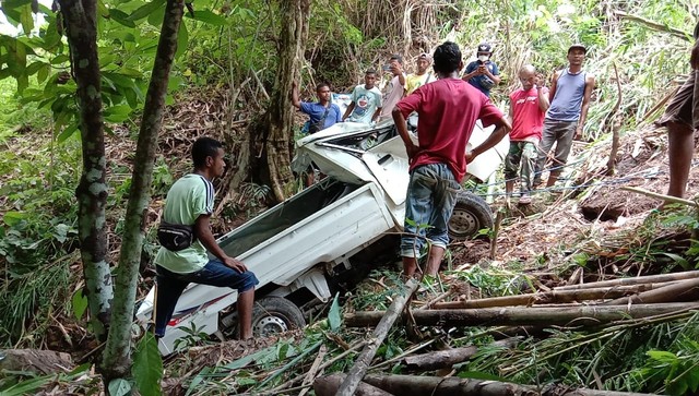 Beberapa warga Desa Gera, Kecamatan Mego sedang berupaya mengevakuasi mobil na'as itu, Selasa (9/11) siang. Foto : Albert Aquinaldo