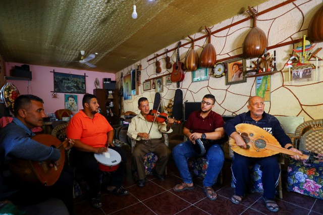 Musisi Palestina Khader El-Bayed melatih para pria cara menggunakan alat musik di Kota Gaza. Foto: Mohammed Salem/REUTERS