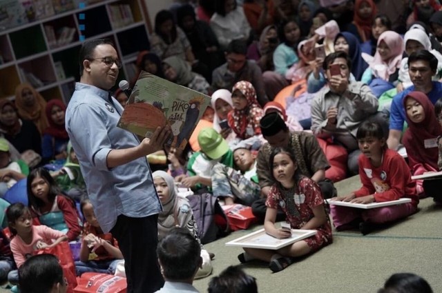 Gubernur DKI Jakarta, Anies Baswedan menunjukkan buku kepada anak-anak. Foto: Instagram/@aniesbaswedan