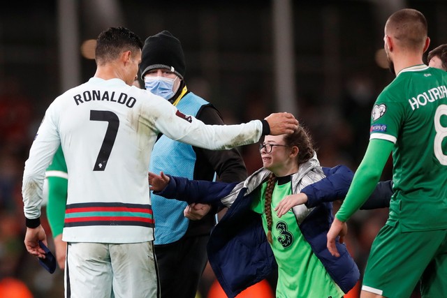 Pemain Portugal Cristiano Ronaldo menyapa seorang fans yang masuk ke lapangan usai pertandingan melawan Irlandia di Stadion Aviva, Dublin, Republik Irlandia. Foto: Paul Childs/REUTERS