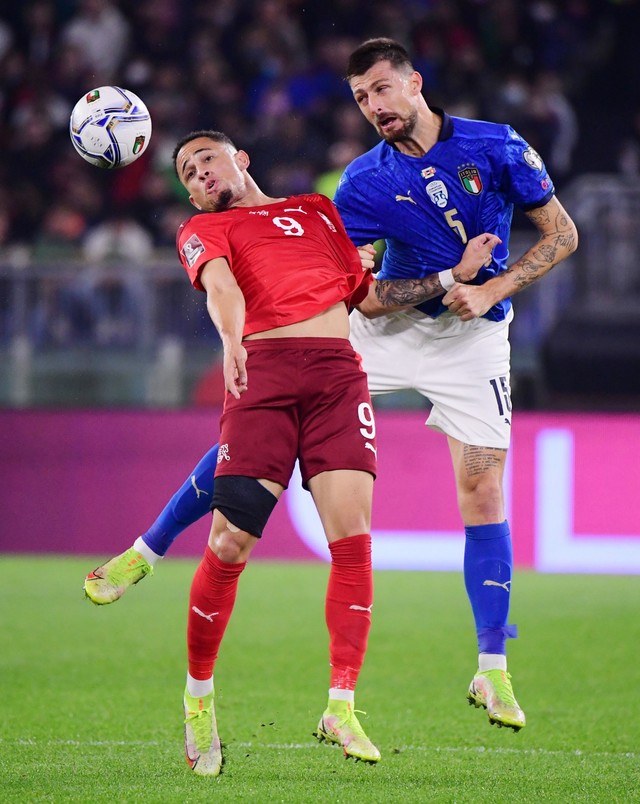 Pemain Swiss Noah Okafor beraksi dengan pemain Italia Francesco Acerbi di Stadio Olimpico, Roma, Italia, Jumat (12/11). Foto: Alberto Lingria/REUTERS